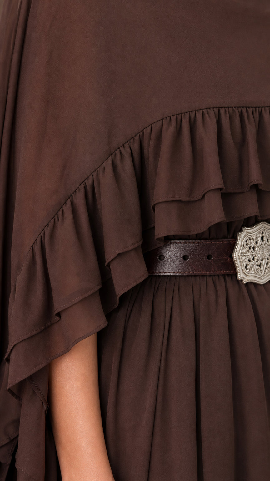 Close-up of fabric texture and ruffle hem on brown cape dress