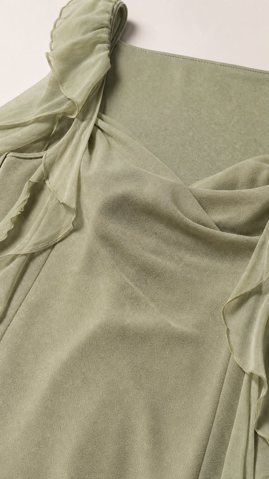 Close-up fabric texture and shoulder detail of sage green dress