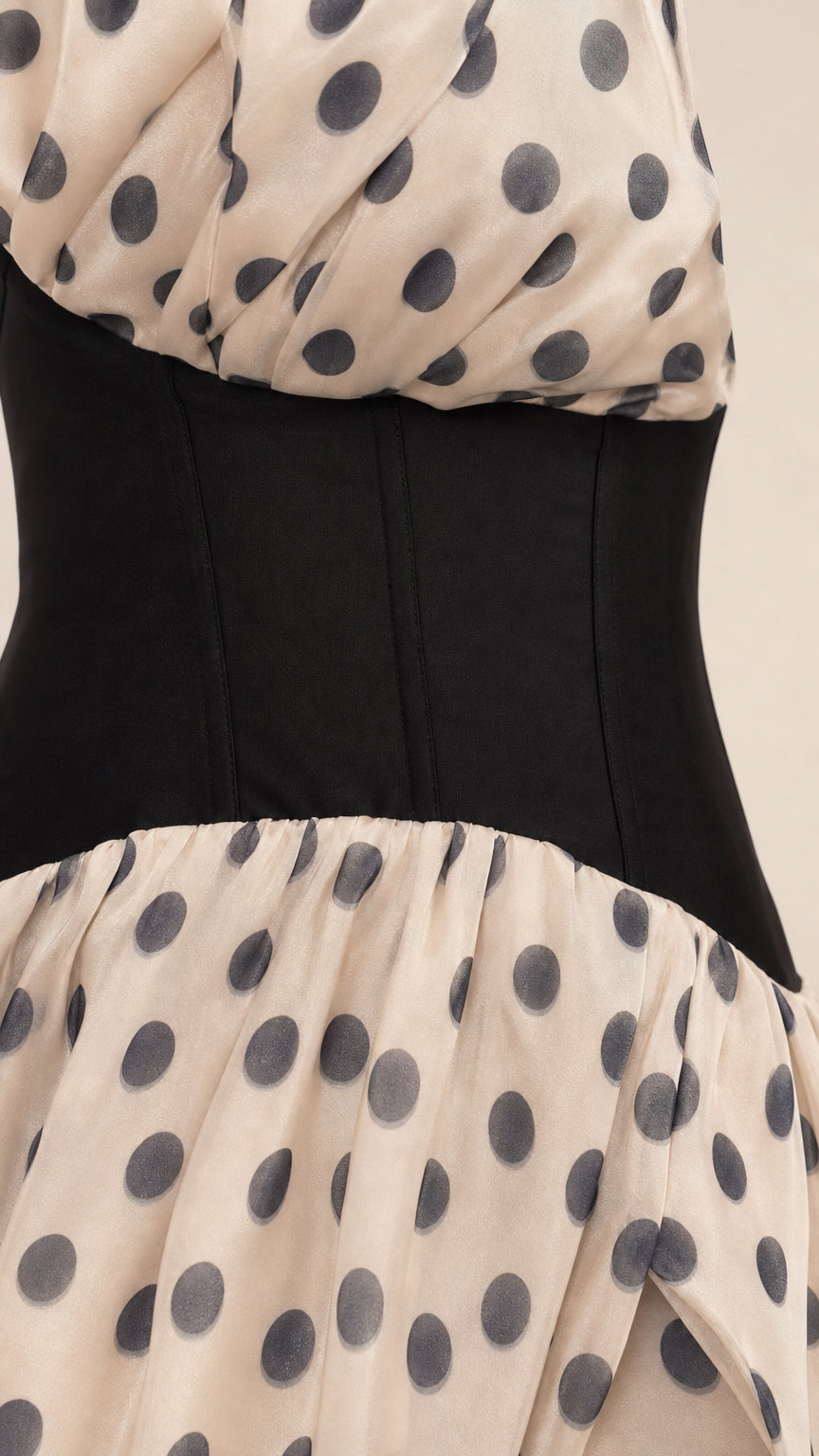 Close-up detail of black corset waist and polka dot fabric