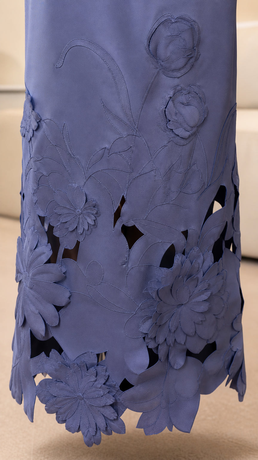 Close-up detail of the laser-cut floral hem on periwinkle dress