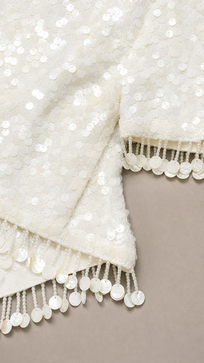 Close-up of white sequin fabric and fringe trim