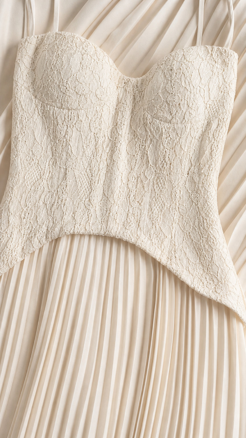 Close-up detail of white lace bodice and pleated skirt