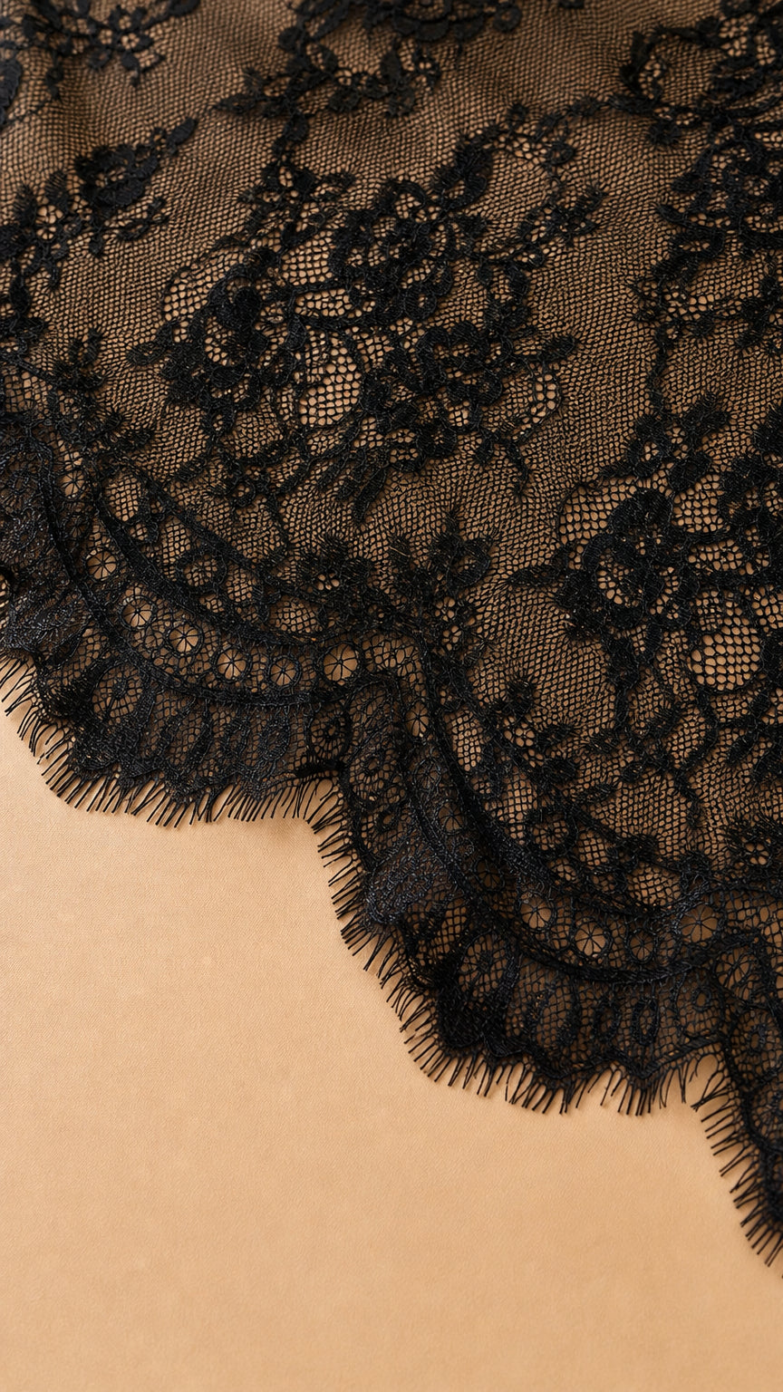 Close up of intricate black floral lace pattern and scalloped hem