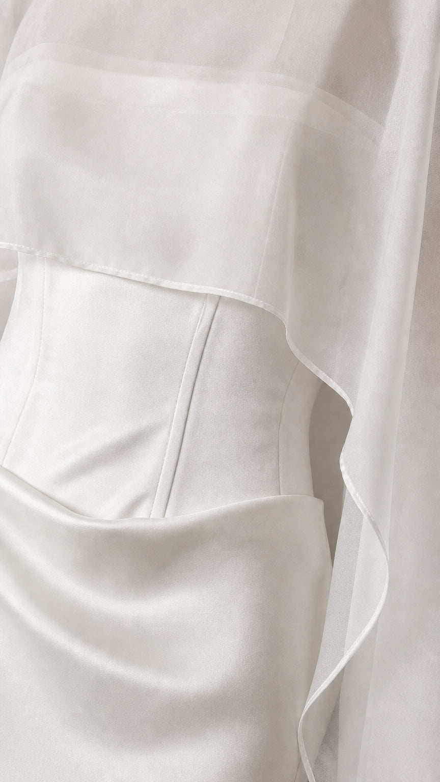 Close-up detail of the bodice and sheer overlay on white dress