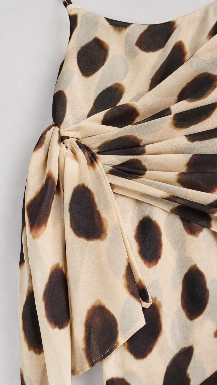 Close-up of fabric and side knot detail on beige dress