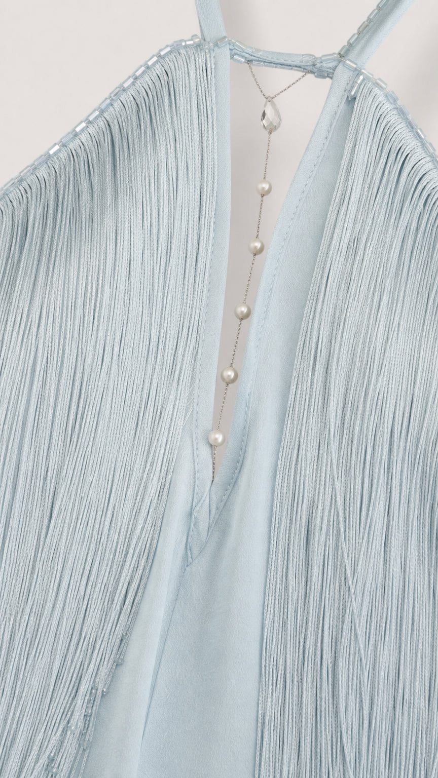 Close-up detail of halter neckline, beading, and fringe on Light Blue dress