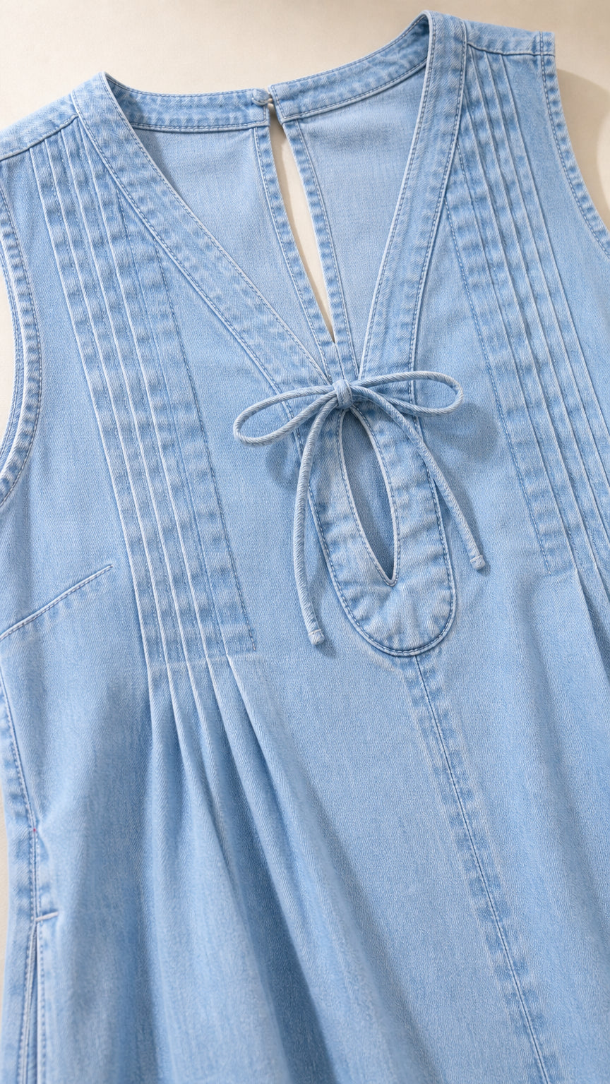 Close-up detail of front tie and pleats on light blue dress
